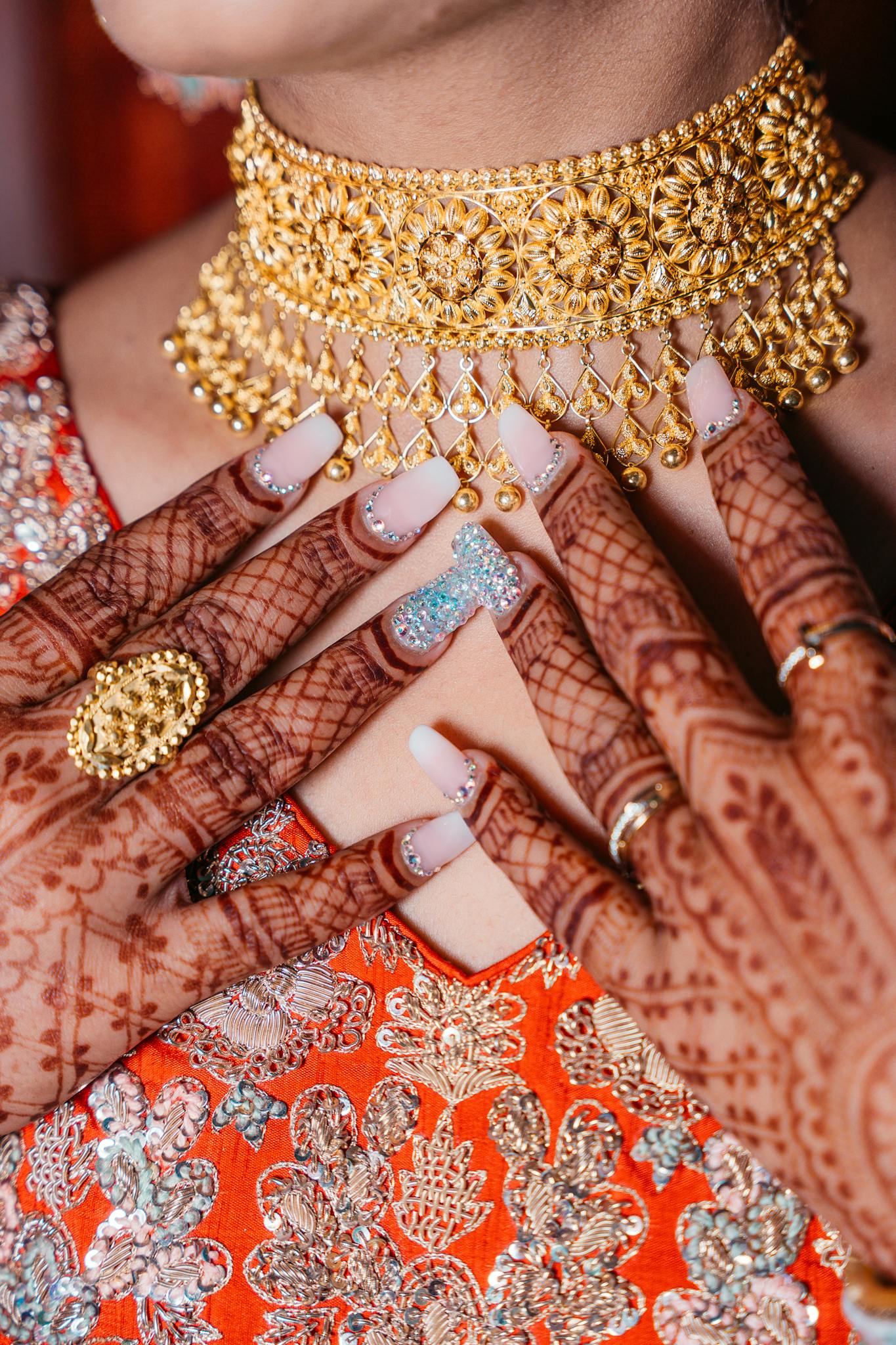 Close-up of henna-adorned hands with jewelry, capturing tradition and elegance.